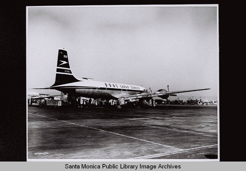 B.O.A.C. Douglas Aircraft Company DC-7 cargo plane on tarmac with equipment