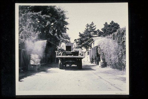 Fly abatement sanitation truck shown spraying benzene hecachloride in a Santa Monica alley