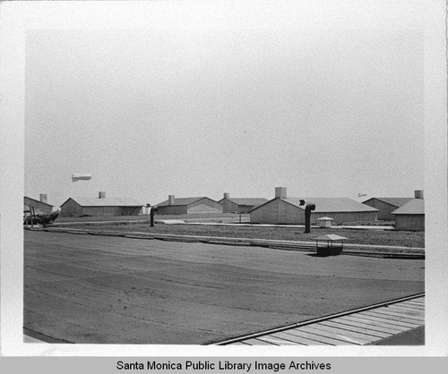 Dirigible (airship) hovers over camouflage neighborhood designed by landscape architect Edward Huntsman-Trout to cover the Douglas Aircraft Company Santa Monica plant and conceal the manufacture of military aircraft during World War II