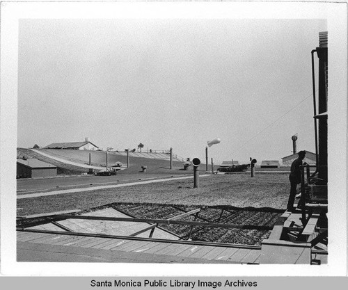 View of vents and a dirigible (airship) hovering in the camouflage neighborhood designed by landscape architect Edward Huntsman-Trout to cover the Douglas Aircraft Company Santa Monica plant during World War II