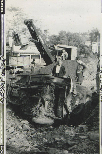 Men standing by an overturned car after the Santa Monica Canyon flood of 1938