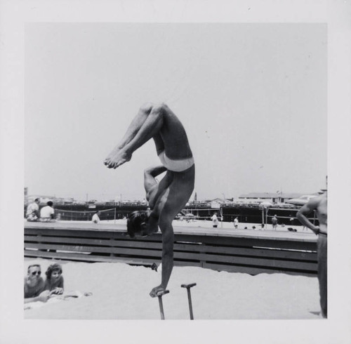 Man working out using pushup stands on Muscle Beach, Santa Monica, Calif