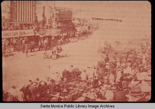 Start/Finish line of the Santa Monica Auto Race on Ocean Avenue with the Number 2 car showing at center and Judges standing across the street