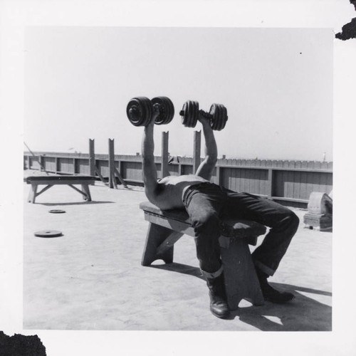 Man lifting weights on Muscle Beach, Santa Monica, Calif