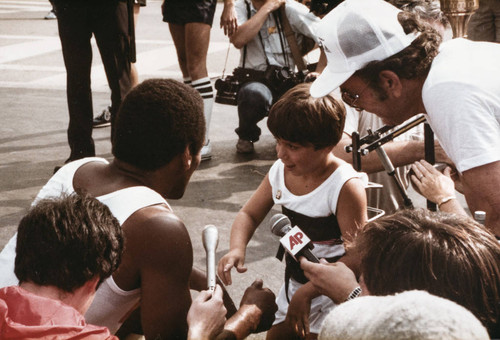 O.J. Simpson speaking to 7-year-old Michael Bailey at Olympic torch relay, July 21, 1984, Santa Monica, Calif