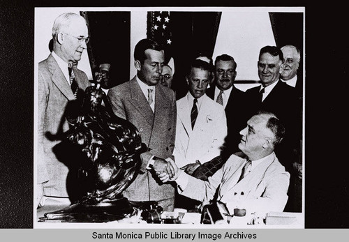 President Franklin Delano Roosevelt (FDR) presents the Robert J. Collier trophy to Donald W. Douglas and the technical and production personnel of the Douglas Aircraft Company for the development of the twin-engine commercial transport airplane in 1935