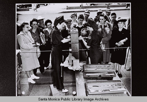 Two Douglas employees demonstrate using tools to a group of women at the Douglas Aircraft Company plant "Opportunity Day" during World War II