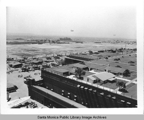 View of camouflage designed by landscape architect Edward Huntsman-Trout during World War II to cover the Douglas Aircraft Company plant at 3000 Ocean Park Blvd.,Santa Monica, Calif. with dirigibles (airships) hovering over the burlap neighborhood