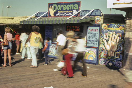 People walking by Doreena the fortune teller on Santa Monica Pier