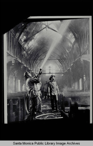 Santa Monica firefighters dousing the interior of a burned church