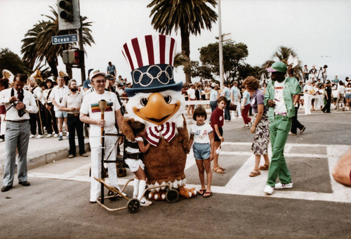 Mascot Sam the Eagle with children at Olympic torch relay on July 21, 1984, Santa Monica, Calif