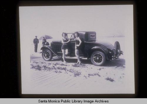 Bathing beauties posing with an automobile on Santa Monica Beach, Calif