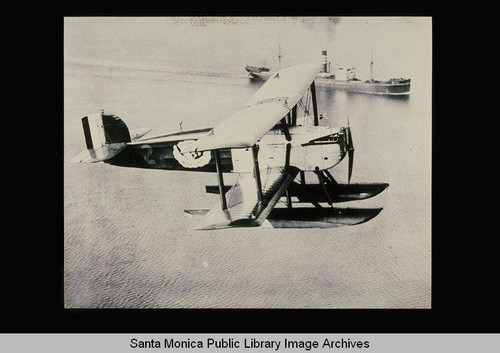 A Douglas World Cruiser on world flight with a ship traveling the ocean below the airplane