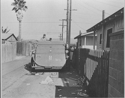 Santa Monica City Sanitation Division worker with street sweeper cleaning alley