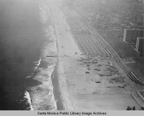 Looking north from the remains of the Pacific Ocean Park Pier to beach parking lots and Santa Monica Shores high-rise in the fog, July 16, 1975