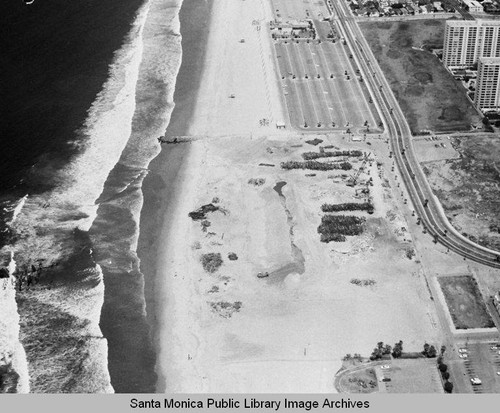 Looking north from the remains of the Pacific Ocean Park Pier at beach parking lots and the Santa Monica Shores Apartments, May 1, 1975, 1:10 PM