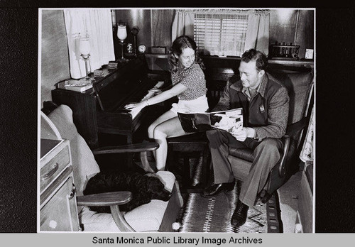 Couple at their piano with a copy of "Douglas Airview" magazine, part of the Douglas Aircraft Company employee housing, World War II