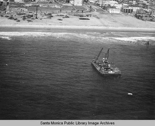 View of the remains of the Pacific Ocean Park Pier and a barge in Santa Monica Bay, July 30, 1975, 10:30 AM