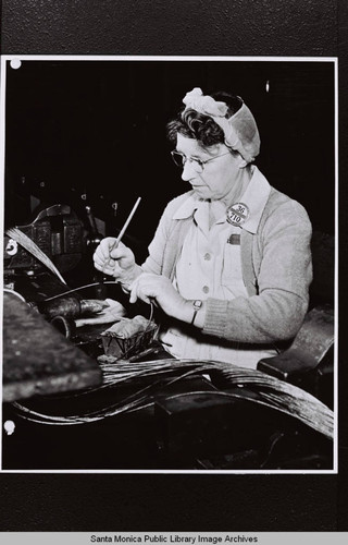 Douglas Aircraft Company Santa Monica plant employee, Malrina Adamson, soldering control cables, World War II