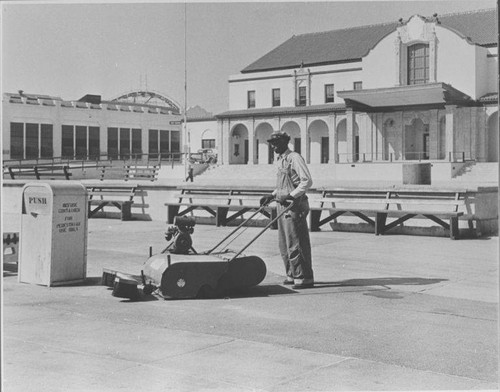 Santa Monica City worker operates a mechanical sweeper in front of the Ocean Park Municipal Auditorium