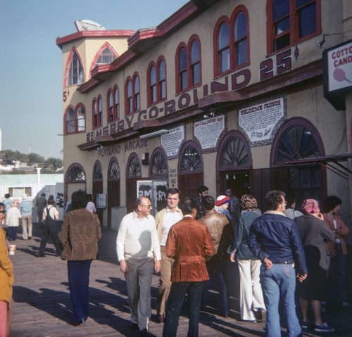 People walking by the Merry-go-round building on Santa Monica Pier