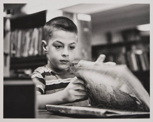 Boy flipping through pages of a book