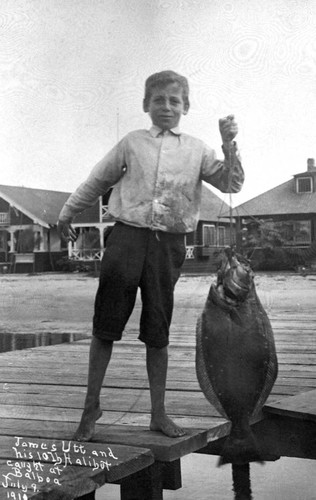 Congressman James Utt as a boy, holding a halibut, Balboa, 1910