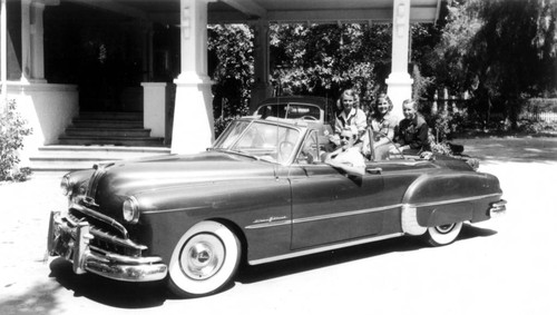Irvine family in their convertible automobile outside their Irvine Ranch home, ca. 1953