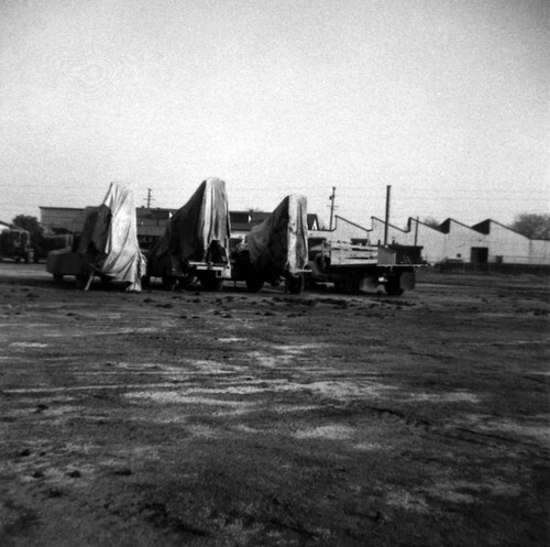 Graves & Howley fumigation rigs at Main and Newport in Tustin, with Mutual Orange Distributors (M.O.D.) packing house in background, Tustin, 1949