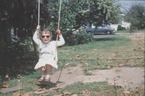 Susi McNeil Simpson on swing in Huntington Beach, 1956