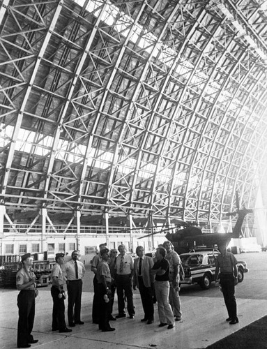 Military personnel and civilians standing inside the Lighter Than Air (LTA) Base, Tustin, ca. 1960