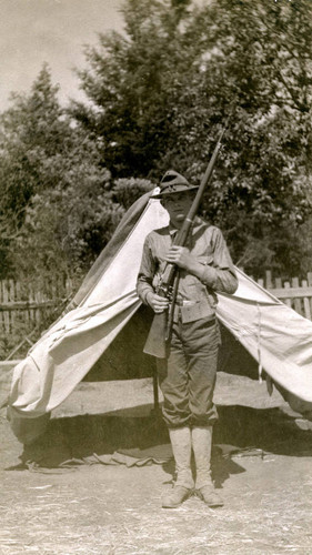 James Harvey Irvine, Jr. in military uniform in front of tent, 1911