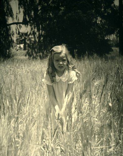 Joan Irvine Smith in a wheat field, ca. 1937