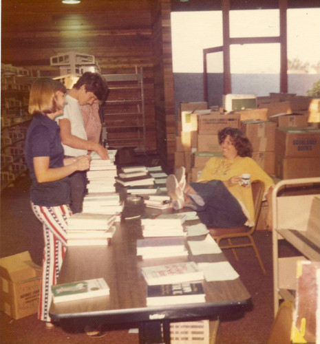 Laura Masoner, library staff member, is seated on the far right, before the opening of University Park Library, 1975