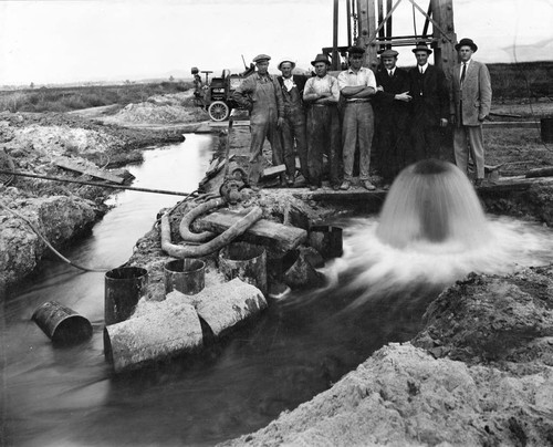 Men standing near artesian well