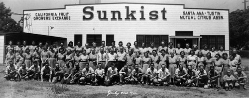 All employees of the Tustin Hills Citrus Association in front of packing plant with Sunkist sign, Tustin