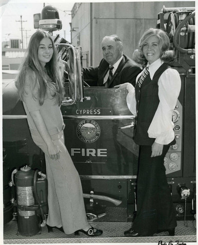 Cypress Volunteer Fire Chief Alfred E. (Pat) Arnold in fire truck with two unidentified women, ca. 1970