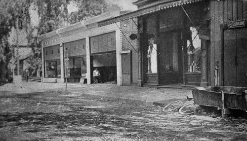 South side of Main Street, Tustin, showing a horse trough in front of the Tustin Building and the three stores to the east, ca. 1910