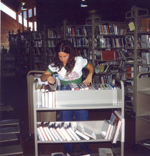 Teri Garza, then 40 hour Library Assistant, sorting books at the University Park Library