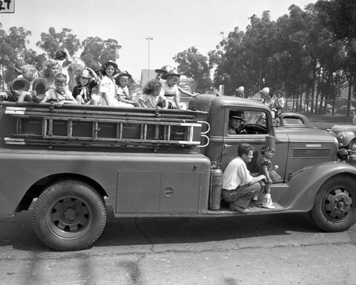 Fire truck with children onboard, Los Alamitos Fall Festival Parade, Los Alamitos, California, September 8, 1951