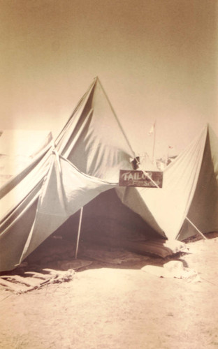 Tent with a sign reading, "Tailor Shop"