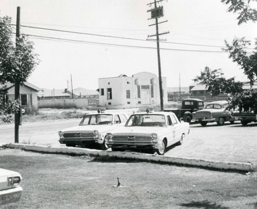 Cypress police department cars in the parking lot, 1962-1967 at 5300 Orange Avenue (current library site)