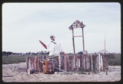 APR87P10-22: fence and waving figure sculpture