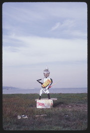 APR87P10-36: figure holding peace sign sculpture