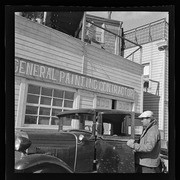 Man getting into car in front of General Painting Contractor building, California Labor School