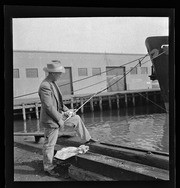 Man fishing on waterfront dock, California Labor School