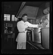 Man stirring large pot in kitchen, California Labor School