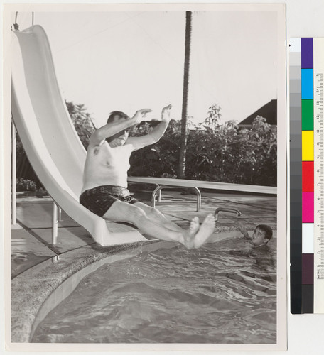 Edmund G. Brown going down a slide into a swimming pool