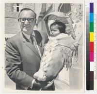 Governor Edmund G. Brown holding a baby in a cradleboard