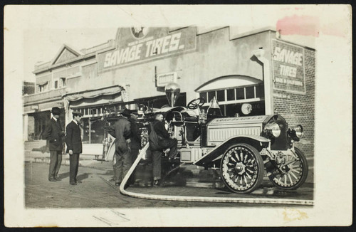 Crew attending to an apparatus in front of Savage Tires